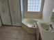 Bathroom with corner bathtub, tiled flooring, and a sink at 2421 E Del Webb Blvd, Sun City Center, FL 33573