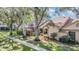 Tan house with brown roof, walkway, and landscaping at 2582 Bentley Dr, Palm Harbor, FL 34684