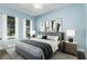 Light blue bedroom with a gray bed and window at 4911 Diamonds Palm Loop, Wesley Chapel, FL 33543