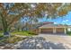 Two-story house with a three-car garage, mature trees, and a large front yard at 5315 Cedarshake Ln, Valrico, FL 33596