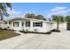 Single-story home featuring white exterior, contrasting trim, and a spacious driveway at 6317 S Lansdale Cir, Tampa, FL 33616