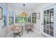 Bright breakfast nook with glass table and chairs, offering view of the backyard at 943 Lucas Ln, Oldsmar, FL 34677