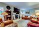 Cozy living room with stone fireplace, leather armchairs, and large TV at 390 Cypress Creek Cir, Oldsmar, FL 34677