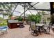 Relaxing screened patio with hot tub, seating area, and dining table at 390 Cypress Creek Cir, Oldsmar, FL 34677