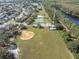 Community overview including a baseball field, tennis court, and residential area at 8622 Thimbleberry Ln, Tampa, FL 33635