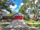 Gray house with red garage door and landscaped yard at 4835 Wellbrook Dr, New Port Richey, FL 34653