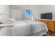 Comfortable bedroom with a striped comforter and wicker dresser at 660 Island Way # 908, Clearwater Beach, FL 33767