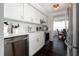 Modern white kitchen features stainless steel appliances and dark hardwood floors at 660 Island Way # 908, Clearwater Beach, FL 33767