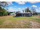 The backyard features an expansive lawn, a screened-in porch, and mature trees at 1283 Coble Rd, Spring Hill, FL 34608