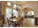 Bright dining room with large chandelier and view to living room at 297 Martellago Dr, North Venice, FL 34275