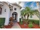 Elegant front entry with arched doorway, lush landscaping, and brick pathway at 297 Martellago Dr, North Venice, FL 34275