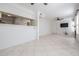 Open-concept living space with tile flooring, a breakfast bar, and a modern ceiling fan at 3020 Bonaventure Cir # 102, Palm Harbor, FL 34684