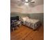 Bedroom with wood floors, built-in shelving, and floral bedding at 1003 W Mahoney St, Plant City, FL 33563