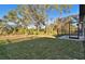 Landscaped backyard with large trees and screened enclosure at 9442 Shorebird Ct, Parrish, FL 34219