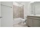 Clean bathroom with a bathtub, toilet and gray cabinets at 9446 Shorebird Ct, Parrish, FL 34219