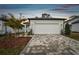 House exterior featuring a white garage door and a paved driveway at 9446 Shorebird Ct, Parrish, FL 34219