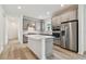 Modern kitchen with gray cabinets and island, white quartz countertops, and stainless steel appliances at 9446 Shorebird Ct, Parrish, FL 34219