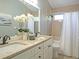 Elegant bathroom featuring double sinks, granite countertop, and a shower/tub combo with decorative white orchids at 15618 Shoal Creek Pl, Odessa, FL 33556