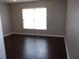 Simple bedroom with dark wood floors and window at 5337 Treig Ln, Wesley Chapel, FL 33545