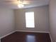 Simple bedroom with dark wood floors and window at 5337 Treig Ln, Wesley Chapel, FL 33545