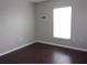 Simple bedroom with dark hardwood floors and a window at 5337 Treig Ln, Wesley Chapel, FL 33545