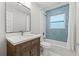 Bathroom with wood vanity, white fixtures, and blue herringbone tile at 623 15Th Nw Ave, Largo, FL 33770