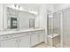 Modern bathroom with double vanity, white cabinets and a walk-in shower at 9458 Shorebird Ct, Parrish, FL 34219