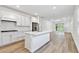 Open concept kitchen with white cabinets, island, and adjacent living area at 9458 Shorebird Ct, Parrish, FL 34219