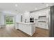 Modern white kitchen with island and stainless steel appliances at 11509 Waterway Dr, Parrish, FL 34219