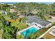 Aerial view of a home with a large pool, fenced yard, and mature trees in a lush, green neighborhood at 164 23Rd Sw Ave, Largo, FL 33778