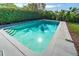 Clear in-ground pool features an open deck and is surrounded by privacy landscaping at 164 23Rd Sw Ave, Largo, FL 33778