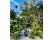 Lush tropical garden with diverse plants & pink umbrella at 105 162Nd Ave, Redington Beach, FL 33708