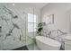 Bathroom with a walk-in shower, freestanding tub, and marble tile at 3405 Loggerhead Way, Wesley Chapel, FL 33544