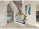 Elegant entryway with staircase, wood-look floors, and modern wall art at 3405 Loggerhead Way, Wesley Chapel, FL 33544