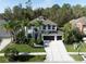 Beautiful two-story home with a spacious driveway, well-manicured lawn and lush tropical landscaping at 3405 Loggerhead Way, Wesley Chapel, FL 33544