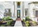 Front entrance with columns, a dark door, and brick walkway at 3405 Loggerhead Way, Wesley Chapel, FL 33544