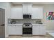 Modern kitchen with white cabinets, stainless steel appliances, and quartz countertops at 3405 Loggerhead Way, Wesley Chapel, FL 33544