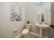 Elegant powder room with floral accent wall and pedestal sink at 3405 Loggerhead Way, Wesley Chapel, FL 33544