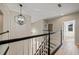 Upstairs hallway with chandelier and wood-look flooring at 3405 Loggerhead Way, Wesley Chapel, FL 33544