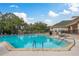 Community swimming pool with surrounding lounge chairs and clubhouse in background at 5935 Precious View Ct, New Port Richey, FL 34655