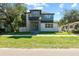 Modern two-story house with gray and white exterior, landscaping, and a paved driveway at 1712 W Arch St, Tampa, FL 33607