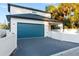 Two-car garage with teal door and paver driveway at 1712 W Arch St, Tampa, FL 33607