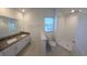 Bathroom boasts double vanity, granite countertop, and shower at 7002 Ripple Pond Loop, Zephyrhills, FL 33541