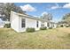 Rear exterior of a white home featuring a lush green lawn and minimal landscaping at 7231 Big Bend Dr, Spring Hill, FL 34606