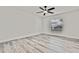 Bright bedroom featuring light wood floors, a modern ceiling fan, and natural light from multiple windows at 7231 Big Bend Dr, Spring Hill, FL 34606