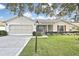 Charming single-story home with a two-car garage, well-manicured lawn, and mature landscaping at 7231 Big Bend Dr, Spring Hill, FL 34606