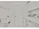 Laundry room includes white washer and dryer, utility sink, and overhead storage at 7231 Big Bend Dr, Spring Hill, FL 34606