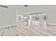 Bright living room with modern flooring and fresh white walls, flowing into the kitchen area at 7231 Big Bend Dr, Spring Hill, FL 34606