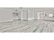 Large open living area with modern floors and fresh white walls, leading to various rooms at 7231 Big Bend Dr, Spring Hill, FL 34606