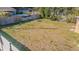 Large backyard with grassy area, fire pit, and wooden fence at 9696 Groveland St, Seminole, FL 33772